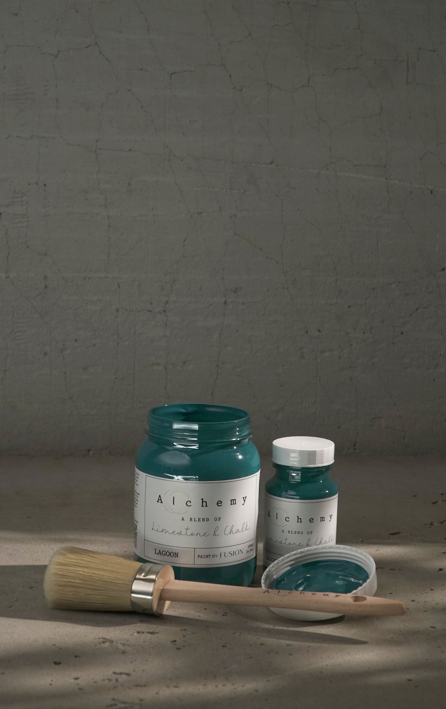 A jar of Alchemy by Fusion chalk paint in a lagoon color, which is a blend of green and blue.