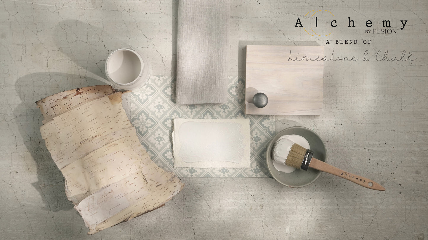 A container of 'Alchemy by Fusion' chalk paint in an off-white color with a label that includes the brand name and product line.