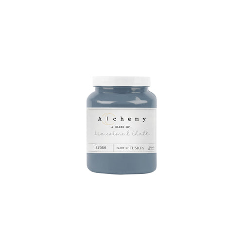 A jar of Alchemy by Fusion chalk paint in a Storm gray color with a lavender undertone.