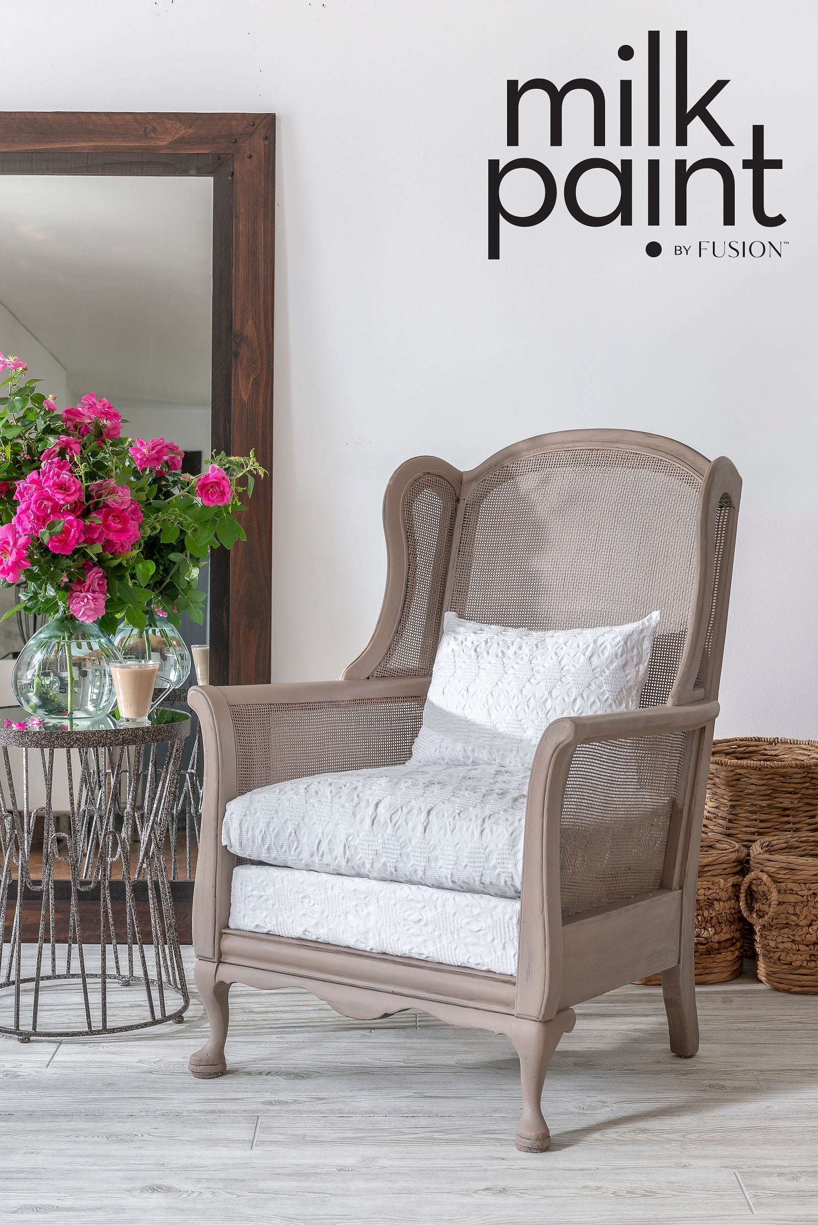 Chair with white cushions in a room with flowers and a mirror, featuring 'milk paint by Fusion' text.