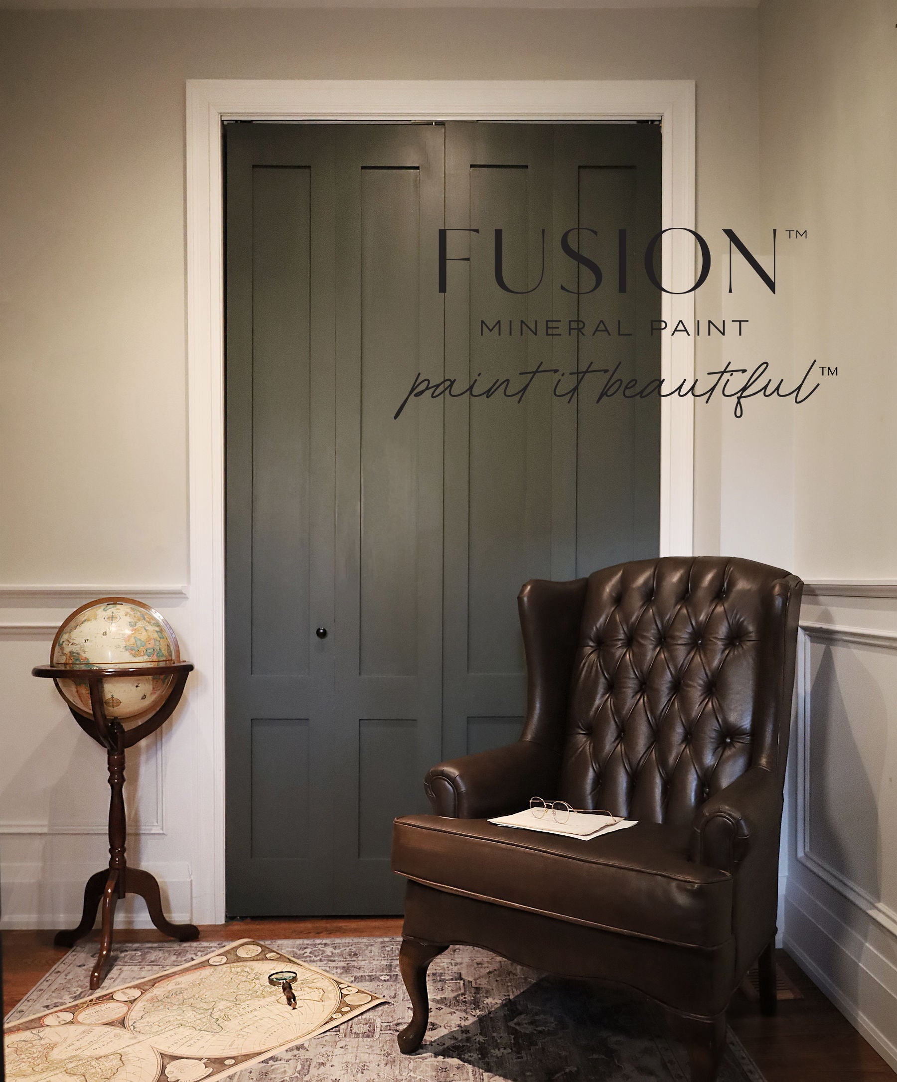 Room with a dark green door, brown leather chair, and vintage globe, featuring Fusion Mineral Paint branding.