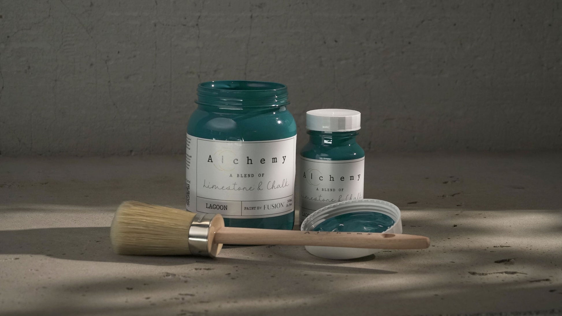 A jar of Alchemy by Fusion chalk paint in a lagoon color, which is a blend of green and blue.