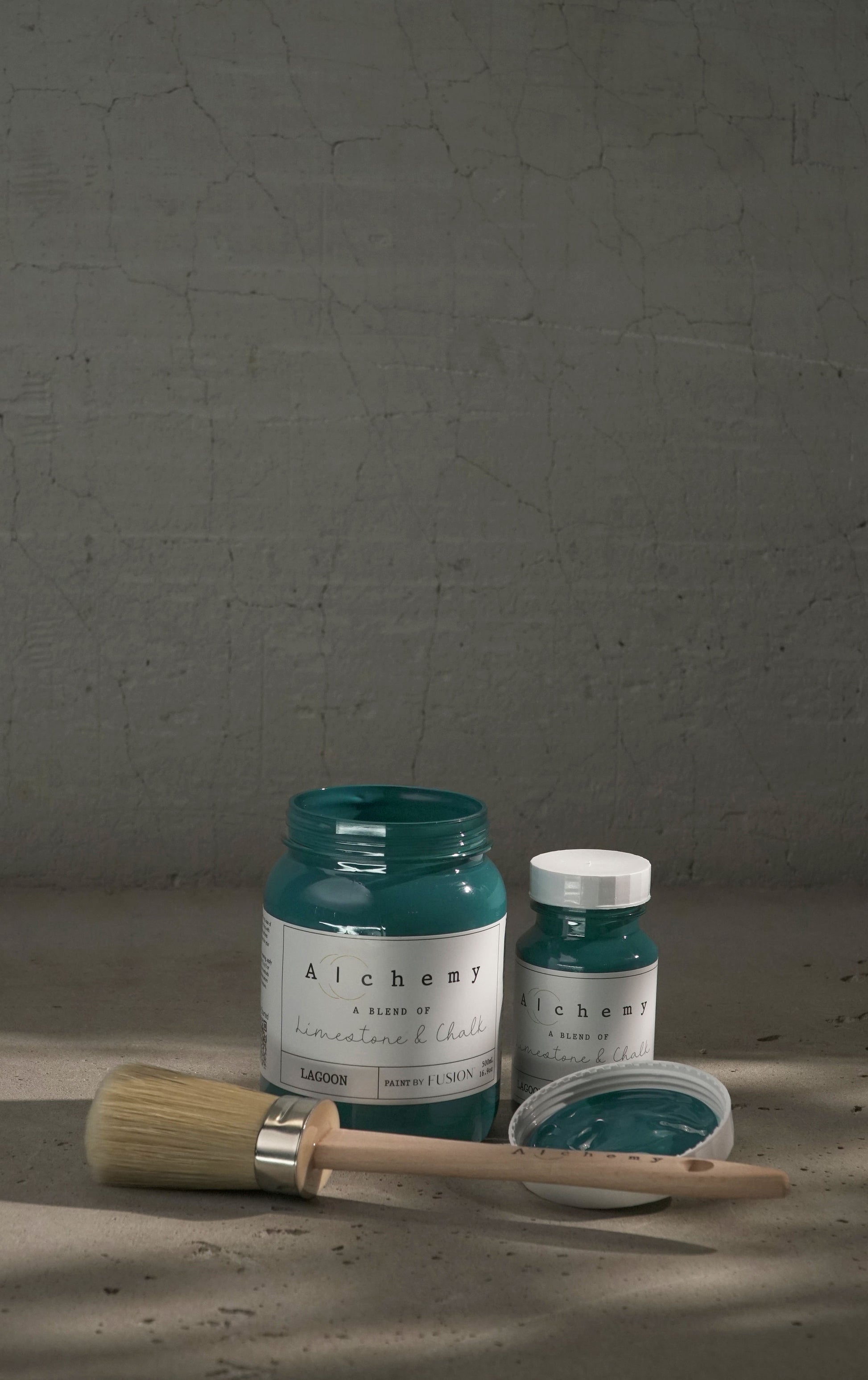 A jar of Alchemy by Fusion chalk paint in a lagoon color, which is a blend of green and blue.