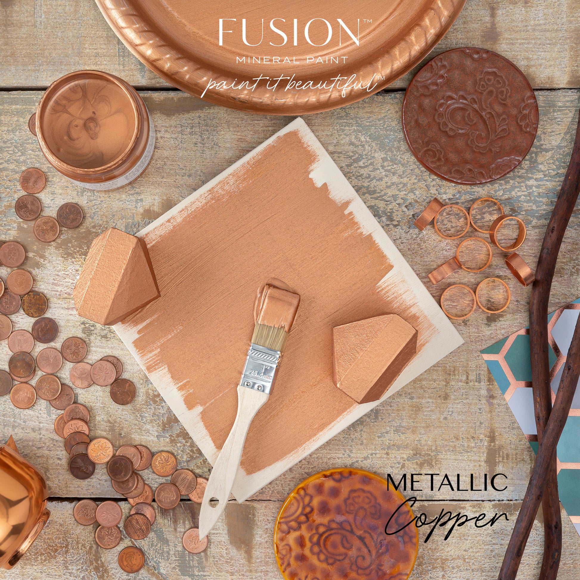Fusion Mineral Paint metallic copper color swatch with paintbrush and decorative elements on a wooden surface.