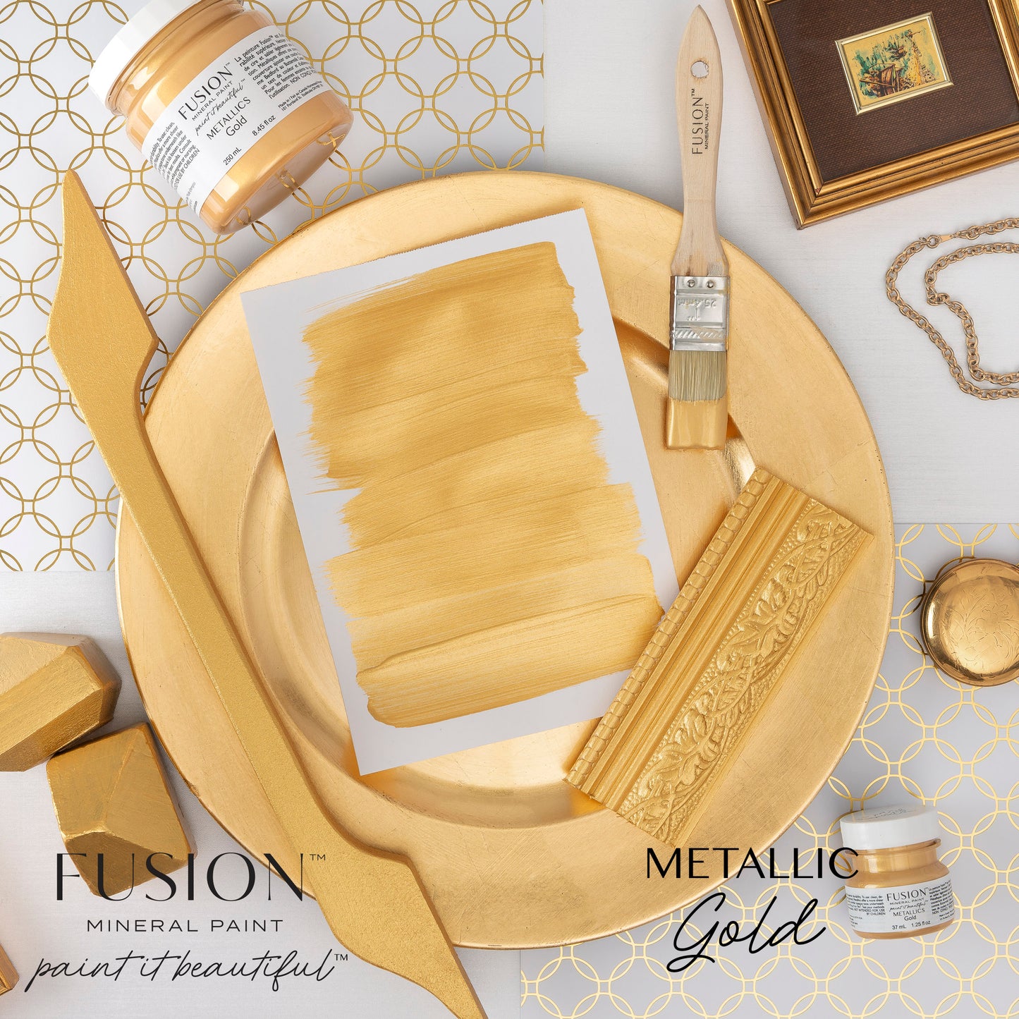 Gold Fusion mineral paint with a brush, jar, and decorative elements on a patterned background.