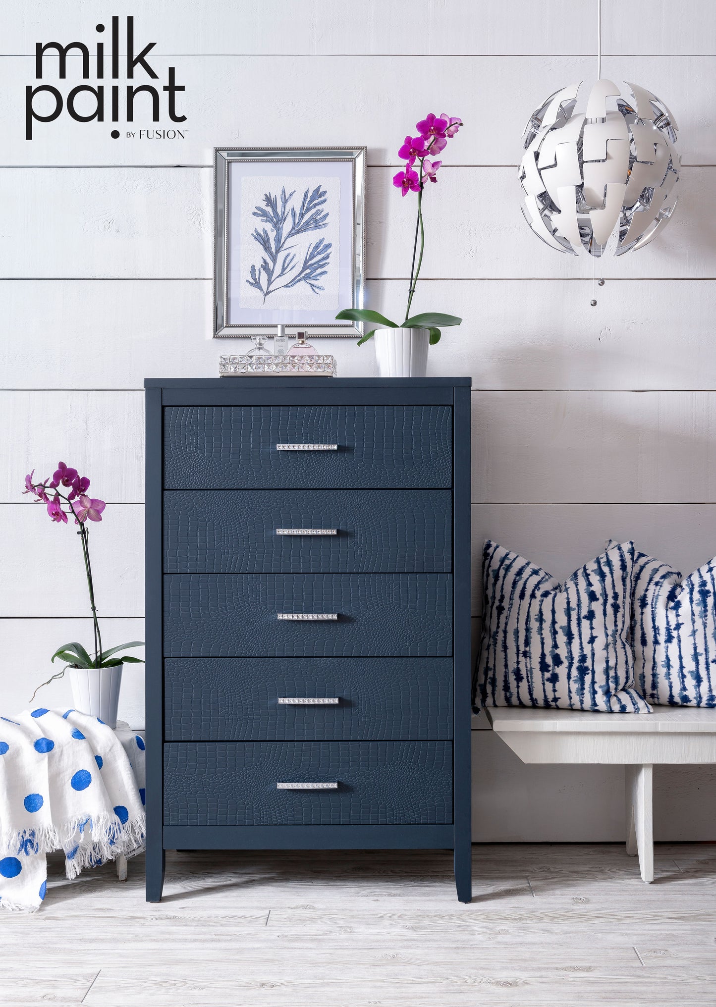 Blue dresser in a room with white walls, a bench, and decorative items.