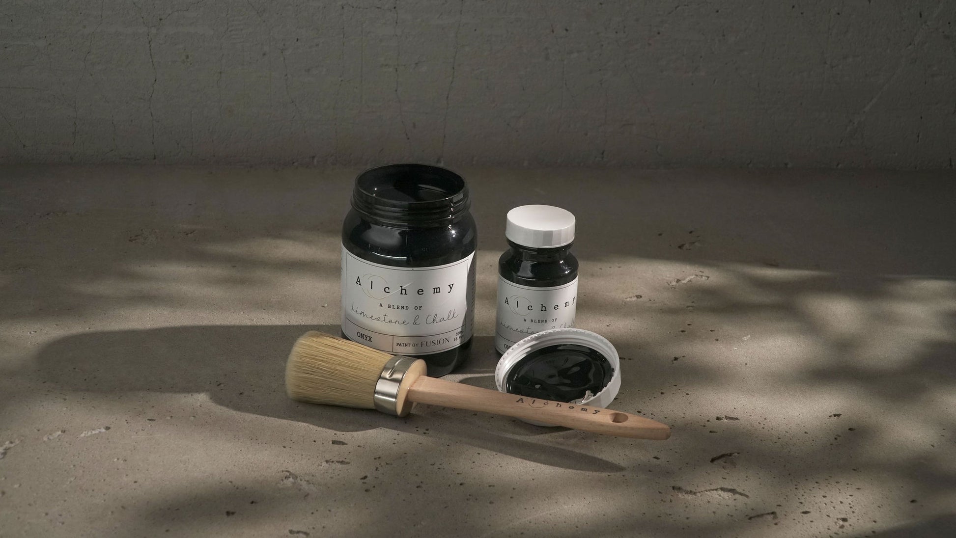 A jar of Alchemy by Fusion chalk paint in black color, with a white label.