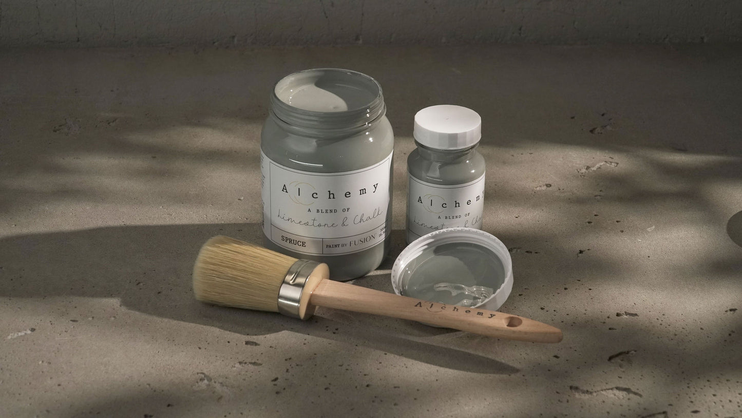 A jar of Alchemy by Fusion chalk paint in a gray color, with a label that includes the product name and the brand's logo.