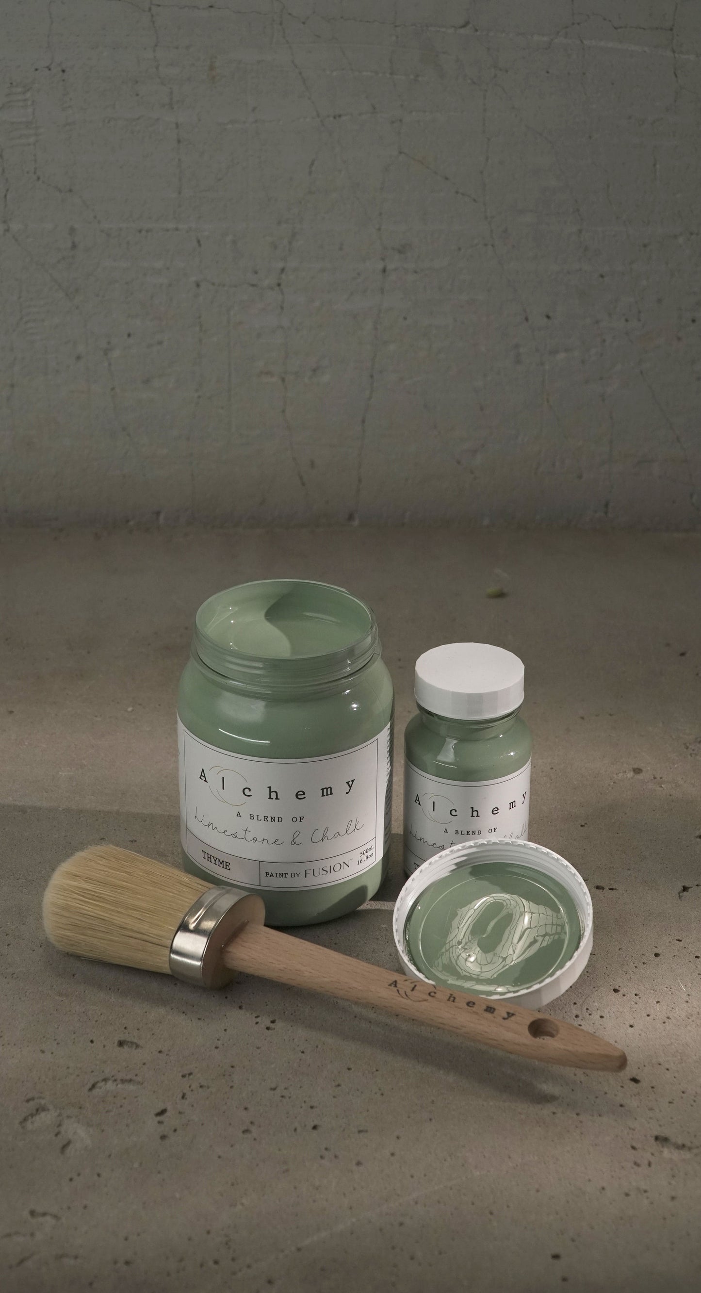 A jar of Alchemy by Fusion chalk paint in a thyme green color, with a white lid and a label that includes the product name and the color 'Thyme'.
