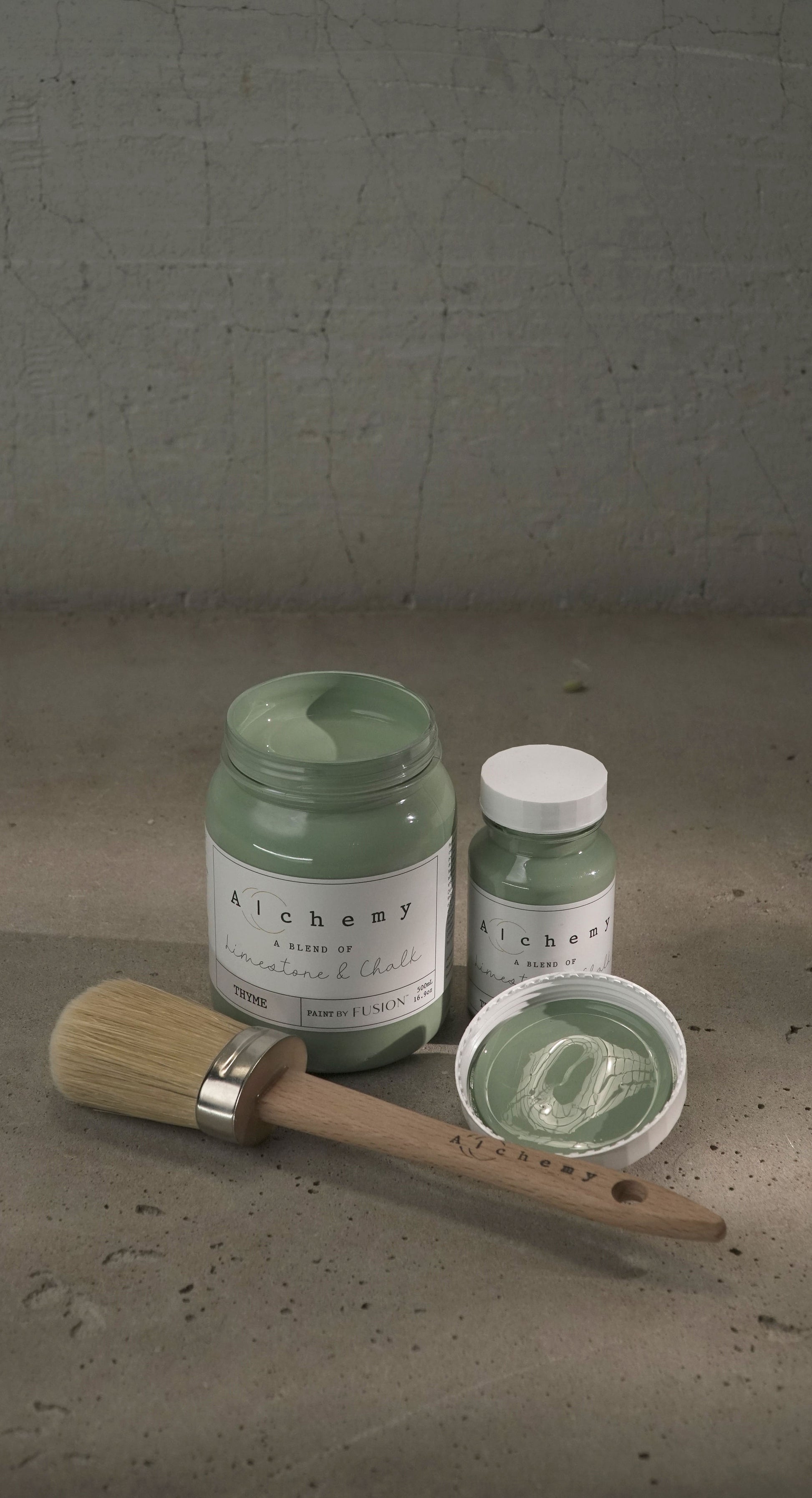 A jar of Alchemy by Fusion chalk paint in a thyme green color, with a white lid and a label that includes the product name and the color 'Thyme'.