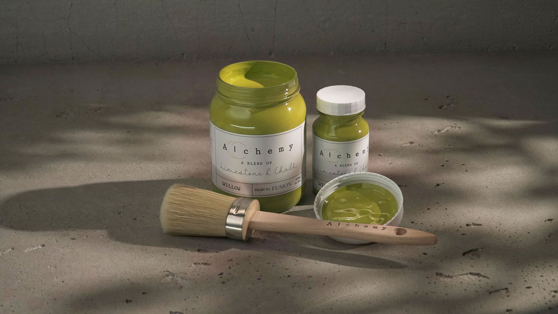 A jar of Alchemy by Fusion chalk paint in the color 'Willow', displaying the product label with white text on a yellow background.