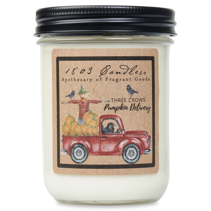 Candle jar with a decorative label featuring a red truck and pumpkins on a white background