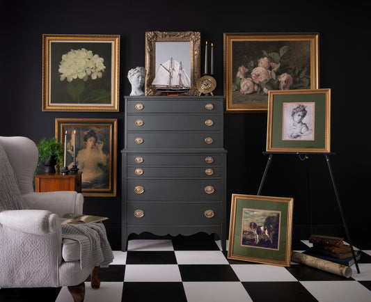 Vintage-style room with dark gray dresser, framed pictures, and a checkered floor.