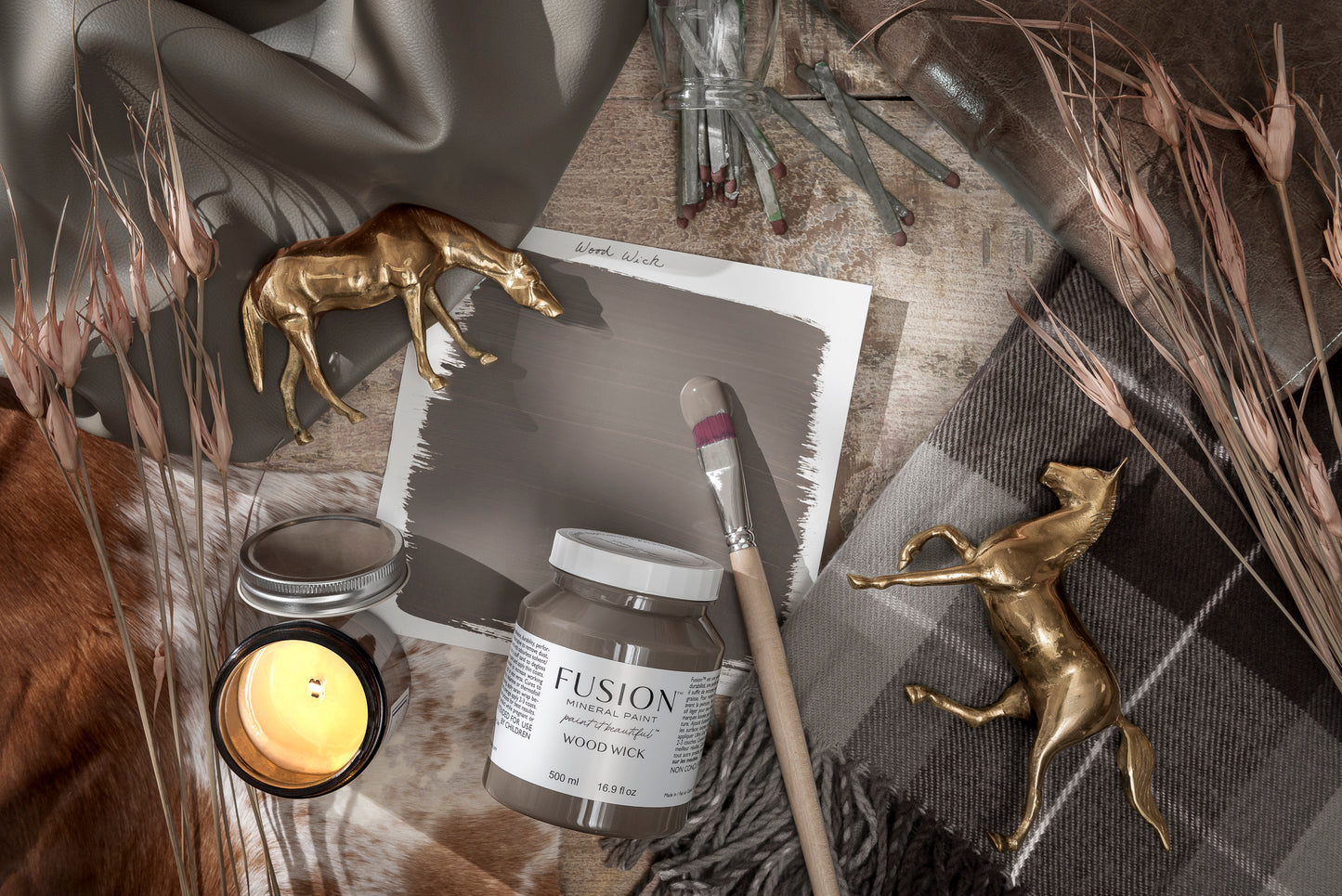 Fusion paint jar with a brush, candle, and decorative elements on a textured surface
